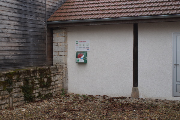 Photo de la cour derrière la mairie; sur le mur du fond on voit le défibrillateur